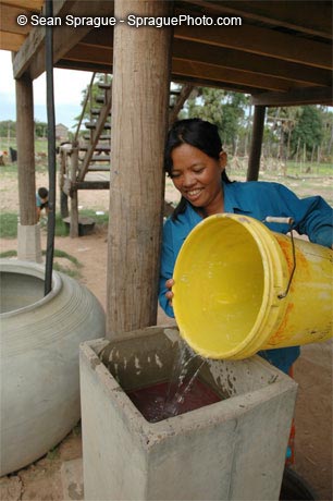 [km05-182+Water+Cambodia+Woman+pouring+water+into+a+sand+filtration+device+to+make+it+safe+for+drinking+Kampong+Chom+Cambodia+]