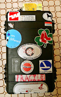 a black suitcase with stickers on it