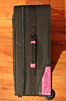 a black suitcase with pink handle