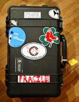 a black suitcase with stickers on it