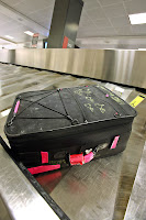 a black suitcase on a conveyor belt