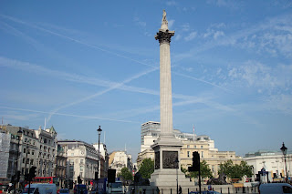 Vapour trails in sky over Trafalgar Square, London