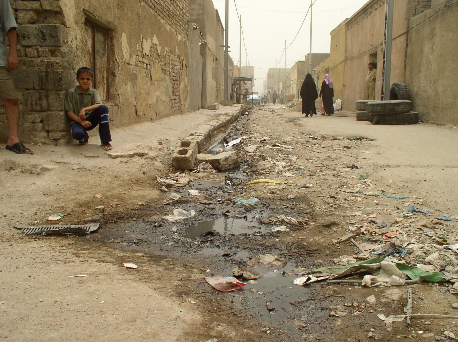 [05_07_24_02_Boy_sits_beside_open_sewage_in_Sadr_City.jpg]