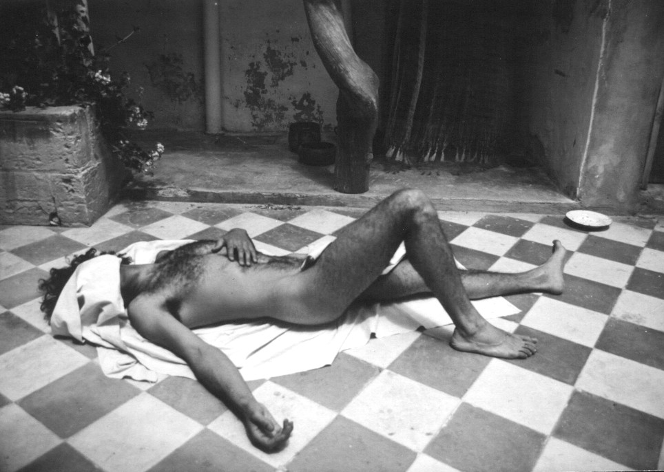 [male-figure-lying-on-checkerboard-dark-and-light-tiles-in-courtyard-mono-AXM.jpg]