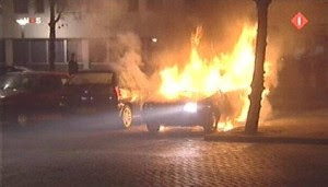 Burning car in front of police station