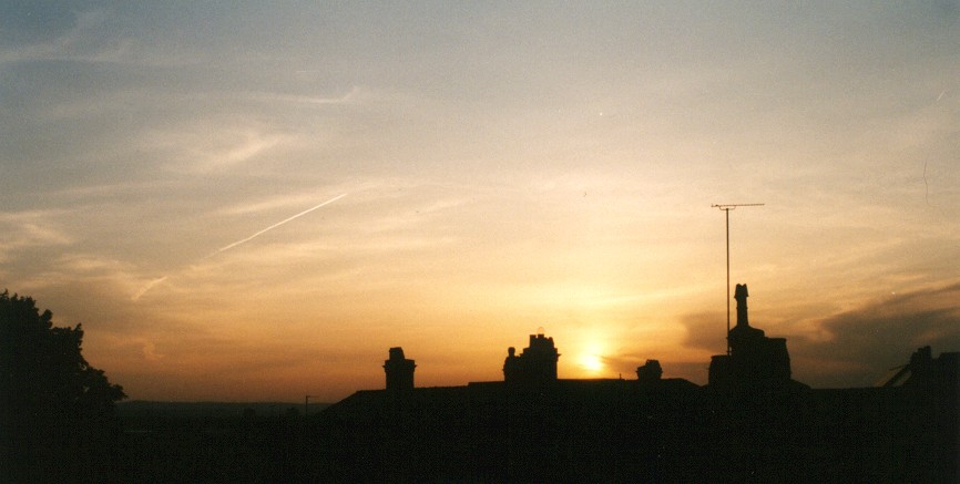 [sunset-over-rooftops-in-Chester-England-seen-from-town-wall-vapour-trail-from-aircraft-in-sky-1-BG.jpg]