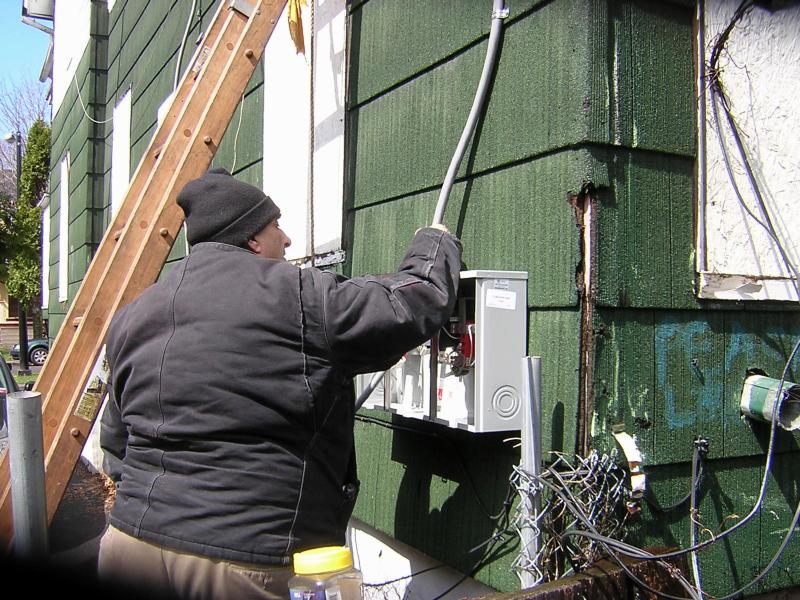 Carmen the Electrician, pulling riser cable through the meter box