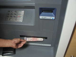 Taking money from ATM booth