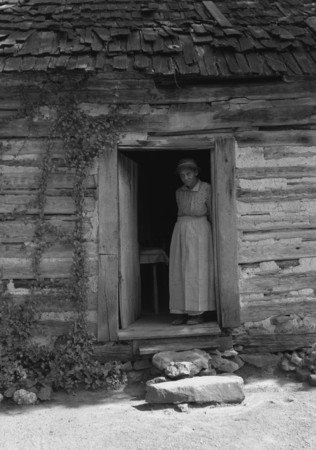 [Dorothea+Lange+photo+of+Caroline+Atwater+standing+in+the+kitchen+doorway+of+double+one+and+a+half+story+log+house,+North+Carolina,+July+1939.jpg]