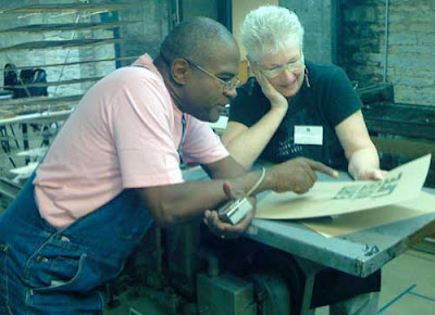 Amos Paul Kennedy conferring with a student in the class