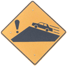 Road sign of a car speeding toward an exclamation point