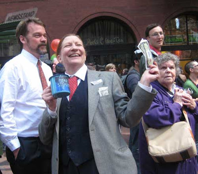 Woman dressed in a business suit holding a mug for handouts and some Bear Stearns bucks