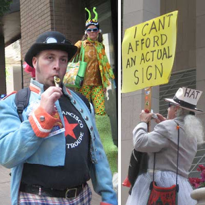 Several people in costume, including one man holding a sign that says I can't afford an actual sign