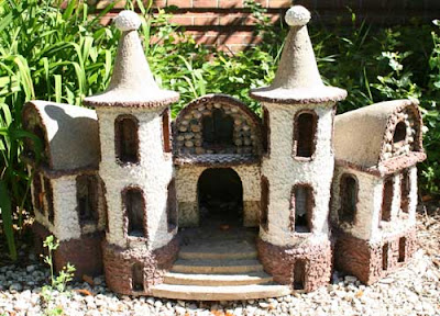 A small central-halled house, stucco, with balls on top of its turrets