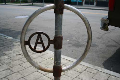 Metal circle with letter A in it, within another circle, part of a parking meter