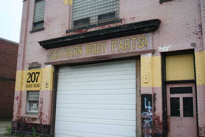 Old brick garage with sign that reads Southern Body Parts!