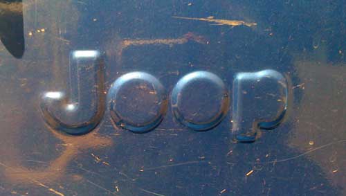 The letters Joop raised in metal on the side of a vehicle