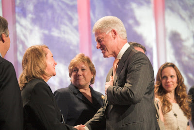 Vicky Colbert and Bill Clinton with hand on his heart