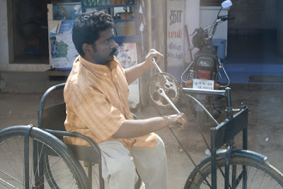 Man using handcrank to power a tricycle
