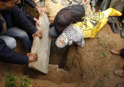 [A+Palestinian+lowers+into+a+grave+the+body+of+one-year-old+girl+Malk+al-Kafarna,+who+medics+say+was+killed+on+Friday+in+an+Israeli+airstrike,+at+Beit+Hanoun+cemetery+in+the+northern+Gaza+Strip+March+1,+2008..jpg]