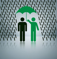 green man shielding black man under umbrella