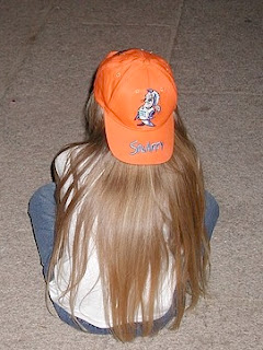 young girl with backwards orange baseball hat