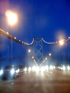 evening photograph of San Francisco Bay Bridge through a dirty or wet car window, photograph by A.E. Graves