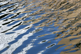 Can Impression #2 shows buildings and blue sky reflected in the River Can as it flows through a concrete bit of Chelmsford