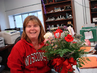 Lisa Rigdon smiling and holding flower on Valentines Day at Runde's